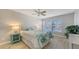 Relaxing bedroom featuring a ceiling fan, a patterned bedspread, and lots of natural light from the window at 4380 Exeter Dr # H202, Longboat Key, FL 34228
