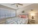 Cozy bedroom with leafy bedding, a ceiling fan, a side table, and lots of natural light from the window at 4380 Exeter Dr # H202, Longboat Key, FL 34228