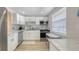 Modern white kitchen featuring stainless steel appliances and bright natural lighting at 4380 Exeter Dr # H202, Longboat Key, FL 34228