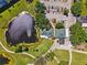 Aerial view of golf course, water feature, trees, and parking area with a charming clubhouse at 4410 Fairways Blvd # 605, Bradenton, FL 34209