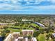 Expansive aerial view of condo buildings nestled within a lush golf course and mature tree canopy at 4410 Fairways Blvd # 605, Bradenton, FL 34209
