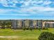 Multi-story beige condo building surrounded by golf course, mature trees and landscaping, seen on a sunny day at 4410 Fairways Blvd # 605, Bradenton, FL 34209