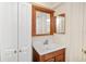 Bathroom featuring cherry vanity with white sink, medicine cabinet and white storage cabinet at 4885 1St Ne St # 308, St Petersburg, FL 33703