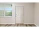 Entryway with wood-style laminate flooring, neutral paint, and a storm door with a large window at 4885 1St Ne St # 308, St Petersburg, FL 33703