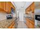 Kitchen featuring oak cabinets, stainless steel appliances, granite countertops, and tile backsplash at 4885 1St Ne St # 308, St Petersburg, FL 33703