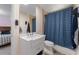 Well-lit bathroom featuring a modern vanity with a white countertop and a blue shower curtain at 6217 Goldfinch St, Sarasota, FL 34241