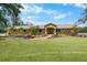 Charming ranch-style home with a well-manicured lawn, mature trees, and beautiful landscaping at 6217 Goldfinch St, Sarasota, FL 34241