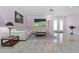 Bright living room featuring tile flooring, white leather seating, and double doors to backyard at 6217 Goldfinch St, Sarasota, FL 34241