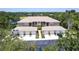 Aerial view of condo building featuring tile roof, garages, and proximity to lush green surroundings at 6334 Grand Oak Cir # 202, Bradenton, FL 34203