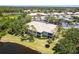 Scenic aerial view of the condo building with beautiful landscaping, pond, and nearby amenities at 6334 Grand Oak Cir # 202, Bradenton, FL 34203