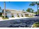 Beige condo building with a row of garages, manicured landscaping, and a glimpse of a blue car at 6334 Grand Oak Cir # 202, Bradenton, FL 34203