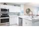 Modern kitchen featuring white cabinets, stainless steel appliances, granite countertops, and a stylish faucet at 6334 Grand Oak Cir # 202, Bradenton, FL 34203