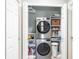 Efficient laundry room with stacked washer/dryer and storage shelves at 6334 Grand Oak Cir # 202, Bradenton, FL 34203