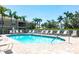 Community pool surrounded by lounge chairs, manicured landscaping, and palm trees, perfect for relaxation at 6334 Grand Oak Cir # 202, Bradenton, FL 34203