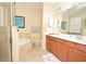 Bathroom featuring double sinks, a soaking tub, and a glass-enclosed shower at 6740 Willowshire Way, Bradenton, FL 34212