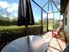 Back patio with privacy hedge offering lovely outdoor space at 6740 Willowshire Way, Bradenton, FL 34212