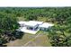 Aerial view of modern architecture, flat roof, and wooded estate at 7200 Chameleon Way, Sarasota, FL 34241