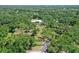 Aerial view of modern home featuring a long driveway through wooded acreage at 7200 Chameleon Way, Sarasota, FL 34241