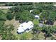 Stunning aerial view of the house and surrounding green landscape with lots of trees and a pond at 7200 Chameleon Way, Sarasota, FL 34241