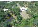 An aerial view of an estate with mature trees, pond, and modern architecture at 7200 Chameleon Way, Sarasota, FL 34241