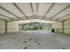Barn interior with a concrete floor and a view of the wooded area outside at 7200 Chameleon Way, Sarasota, FL 34241