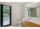 Bathroom showcasing a wood vanity, modern fixtures, and a view to the outside at 7200 Chameleon Way, Sarasota, FL 34241