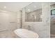 Contemporary bathroom featuring a free-standing tub, glass shower, and marble tile at 7200 Chameleon Way, Sarasota, FL 34241