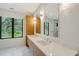 Modern bathroom with double vanity, marble tile, large mirrors, and window view at 7200 Chameleon Way, Sarasota, FL 34241