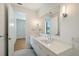Bright bathroom featuring a double vanity with modern fixtures and large mirror at 7200 Chameleon Way, Sarasota, FL 34241