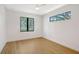 Minimalist bedroom featuring hardwood floors and clean lines, bathed in natural light from the windows at 7200 Chameleon Way, Sarasota, FL 34241