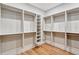 Spacious walk-in closet with custom shelving and wooden floors, offering plenty of storage at 7200 Chameleon Way, Sarasota, FL 34241