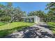 Modern, light-filled home with a minimalist design and lush landscaping, set against a clear blue sky at 7200 Chameleon Way, Sarasota, FL 34241