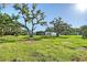 Exterior of modern home with mature trees and lush green grass at 7200 Chameleon Way, Sarasota, FL 34241