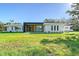 Modern home featuring a sleek, minimalist design with lush green lawn and manicured landscaping at 7200 Chameleon Way, Sarasota, FL 34241