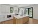 Modern kitchen featuring white cabinets, marble countertops, and a wooden island at 7200 Chameleon Way, Sarasota, FL 34241