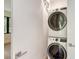 Efficient laundry area showcasing a stacked washer and dryer setup with outside views through a window at 7200 Chameleon Way, Sarasota, FL 34241