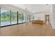 Open-concept living space with hardwood floors and floor-to-ceiling windows offering scenic backyard views at 7200 Chameleon Way, Sarasota, FL 34241