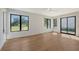 Open room with hardwood floors, large windows, and glass doors, providing an abundance of natural light at 7200 Chameleon Way, Sarasota, FL 34241