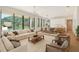 Bright, open-concept living room featuring large windows and modern furnishings, seamlessly flowing into the dining area at 7200 Chameleon Way, Sarasota, FL 34241