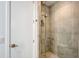 The frameless shower features stone tiles and a rain shower head at 7200 Chameleon Way, Sarasota, FL 34241