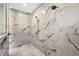 Modern shower with marble tile, a rainfall shower head, and a built-in niche at 7200 Chameleon Way, Sarasota, FL 34241