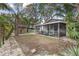 Spacious backyard with screened porch, tropical landscaping, and a charming storage shed for outdoor enjoyment at 7795 Wright Ave, Sarasota, FL 34231