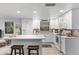 Modern white kitchen with stainless steel appliances and a large island with seating at 7795 Wright Ave, Sarasota, FL 34231