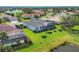 Aerial view of home featuring a screened-in pool, manicured lawn, and lush landscaping at 8718 Grey Oaks Ave, Sarasota, FL 34238