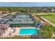 Aerial view of resort-style community showcasing a pool, tennis courts and putting range with lush landscaping at 8718 Grey Oaks Ave, Sarasota, FL 34238