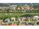 Stunning aerial showcasing lush neighborhood homes with golf course, pond and city views at 8718 Grey Oaks Ave, Sarasota, FL 34238