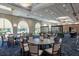 Elegant dining area with round tables, comfortable chairs, and large windows offering scenic views at 8718 Grey Oaks Ave, Sarasota, FL 34238