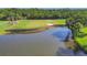 Beautiful view of a golf course featuring a pond, green, and bunkers, bordered by a wooden retaining wall at 8718 Grey Oaks Ave, Sarasota, FL 34238