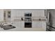 Bright kitchen featuring stainless appliances, light countertops, and white cabinets at 8718 Grey Oaks Ave, Sarasota, FL 34238