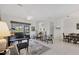 Bright living room with a piano and access to the pool area via sliding glass doors at 8718 Grey Oaks Ave, Sarasota, FL 34238